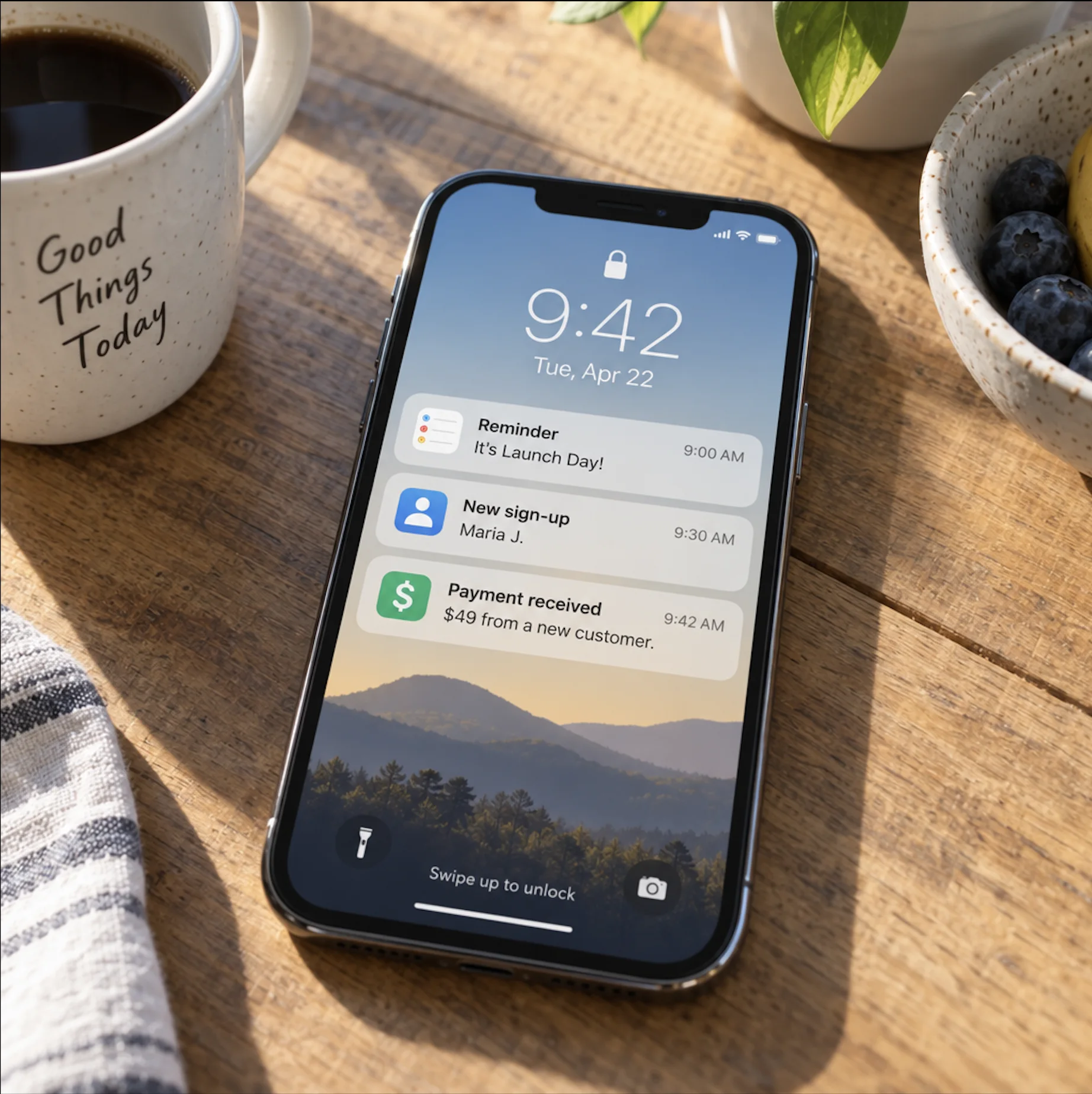 A phone on a breakfast table showing launch day: a reminder, a new sign-up and a first payment.